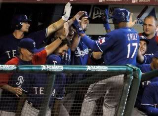 Texas Rangers' Nelson Cruz (17) is welcomed back into the dugout after hitting a home run, his second of the game.